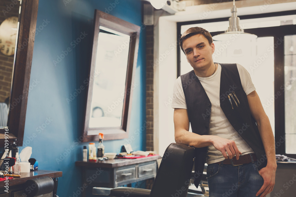 Barber invites to have seat on chair at barbershop Barber invites to have seat on chair at barbershop