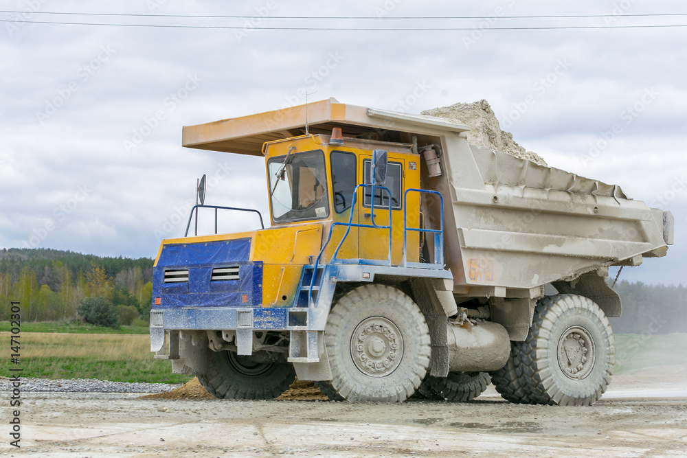 Large-yellow quarry dump trucks produce transportation of minerals Large-yellow quarry dump trucks produce transportation of minerals