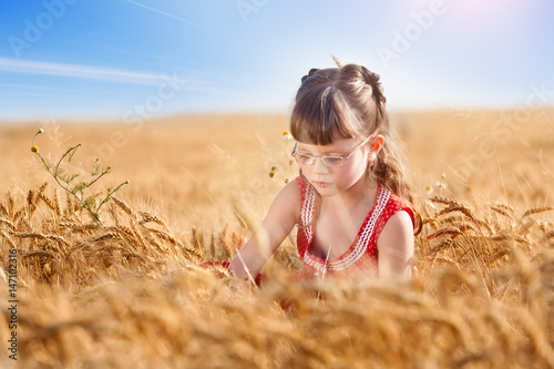 Little girl playing in a wheat field,copy space