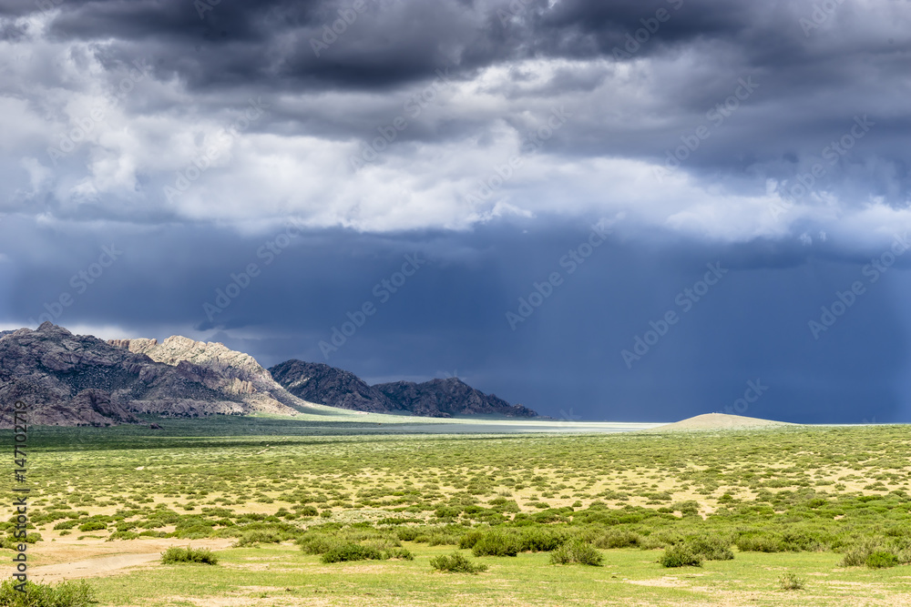 Fototapeta premium Heavy thunderstorm during a summer day over the sparse Mongolian landscape