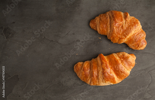 Top View of two fresh croissants on grey slate