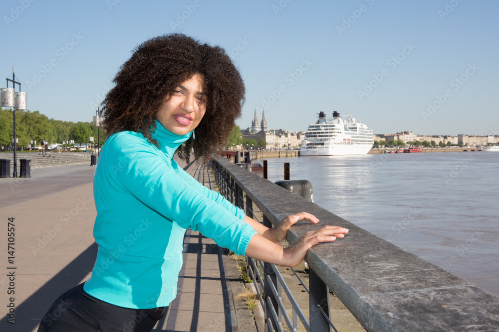 cheerful black mixed woman sport in city river
