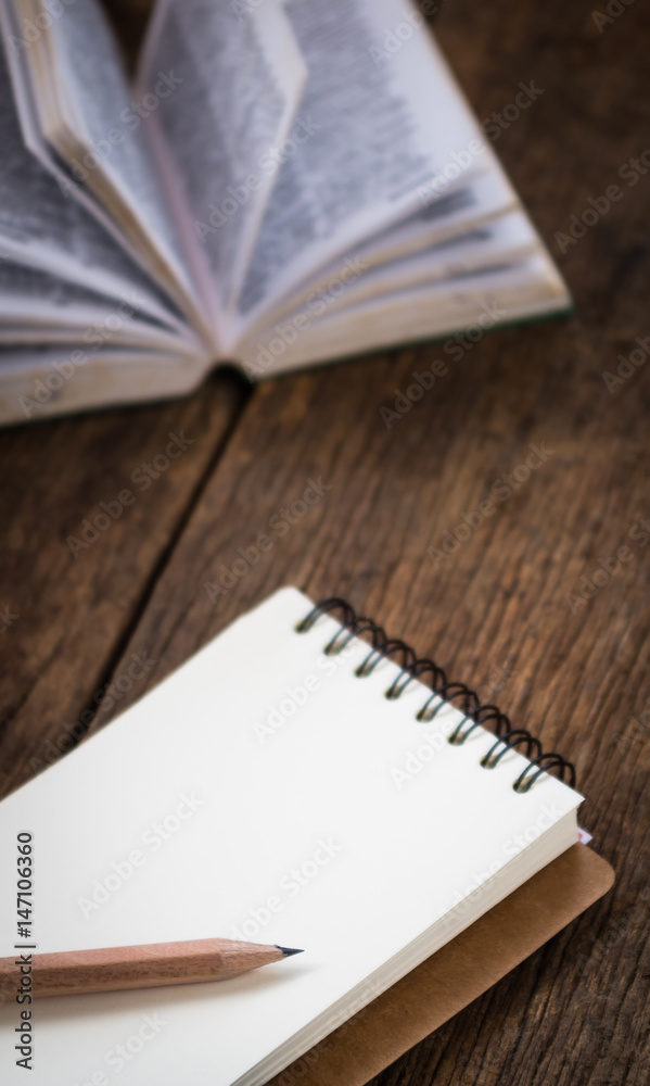 Naklejka premium Blank notebook with book on wooden table