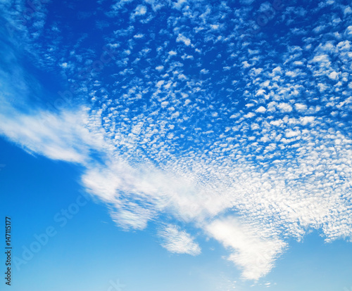 Blue sky with many fluffy white clouds. Natural background.