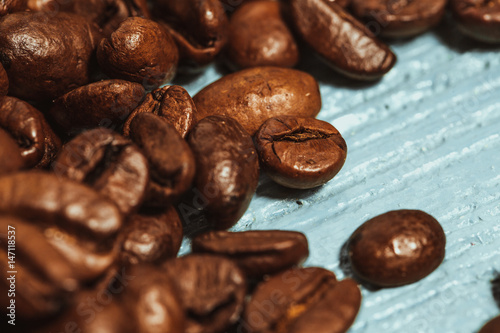 Dark many roasted coffee beans on blue background photo
