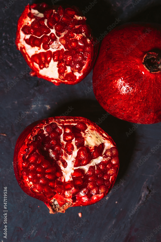 red sliced pomegranate on a blue abstraction background red sliced pomegranate on a blue abstraction background