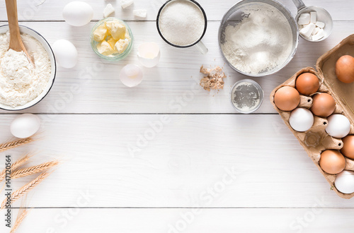 Fotografia Baking ingredients on white rustic wood background, copy space