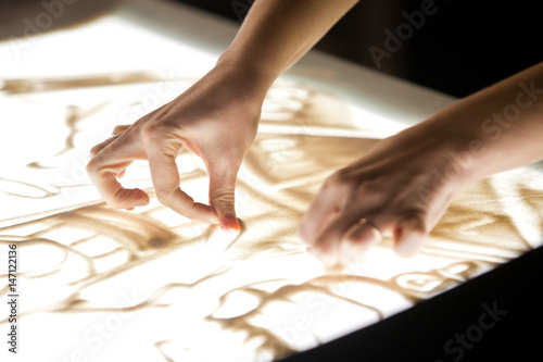 Sand animation. Girl's hands drawing sand closeup 