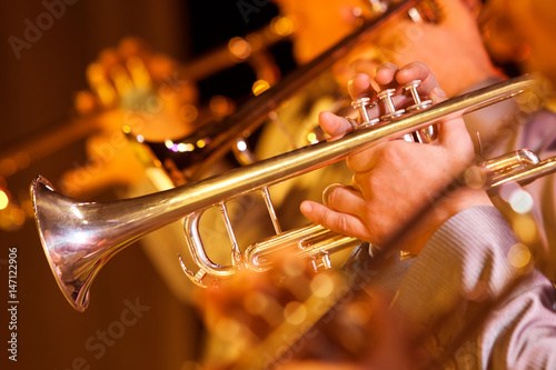  Hands of man playing the trumpet in the orchestra closeup