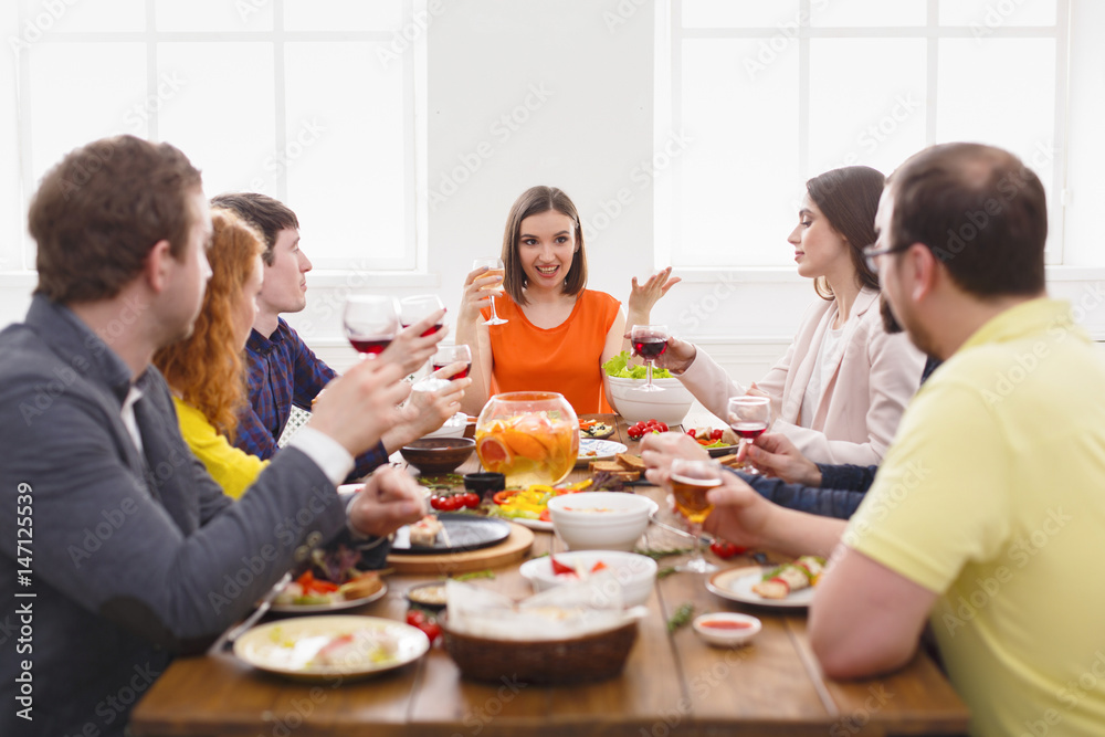 Group of happy people at festive table dinner party