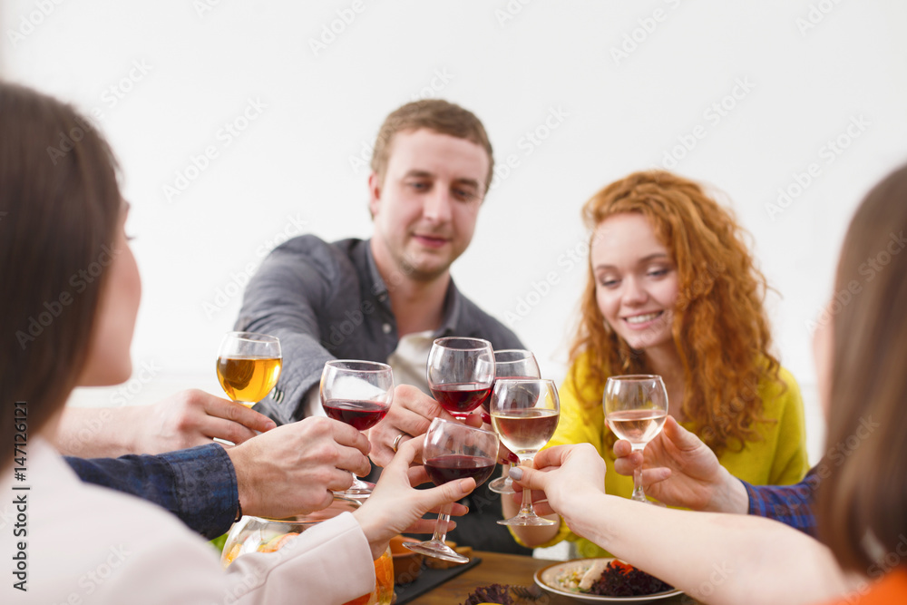 Group of happy young people at dinner table, friends party