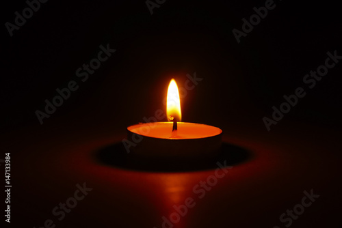 The light of burning candle in the dark