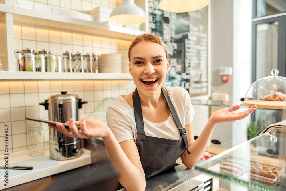 Excited saleswoman using mobile phone in cafeteria Excited saleswoman using mobile phone in cafeteria
