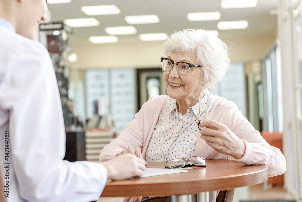Happy smiling senior lady keeping eyewear Happy smiling senior lady keeping eyewear