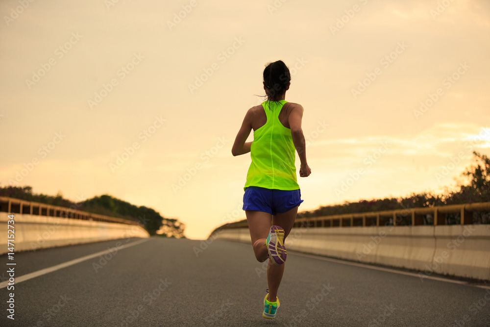 Healthy lifestyle young fitness woman running at sunrise city road