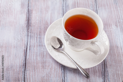 Tea in a white cup on a wooden background