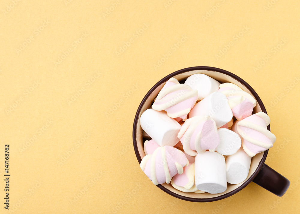 Sweet marshmallow in cup, candy on yellow background, top view flat lay. Isolated minimal concept above decoration, view white marshmallow, food background