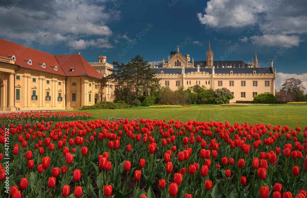 Beautiful view of Lednice Castle with storm clouds and blooming red tulips.Lednice palace is one of the most impressive and  visited historical sights in the Czech Republic. South Moravia attractions