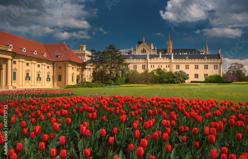 Beautiful view of Lednice Castle with storm clouds and blooming red tulips.Lednice palace is one of the most impressive and visited historical sights in the Czech Republic. South Moravia attractions