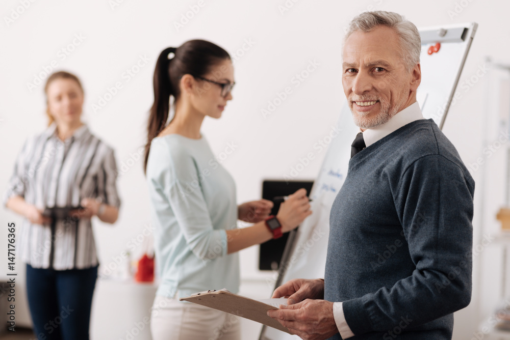 Smiling male person holding folder in left hand Smiling male person holding folder in left hand