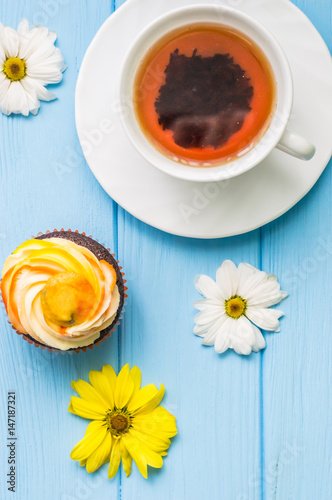 Still life with cup of tea and cake on the wooden background