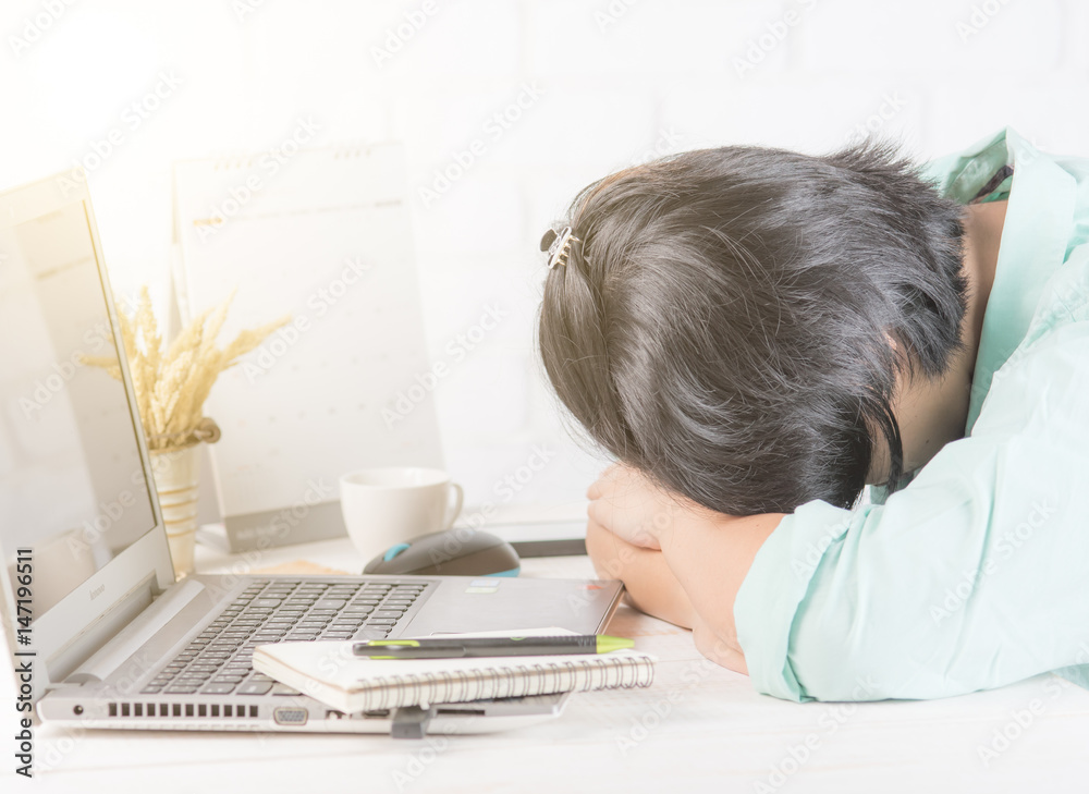 Tired businesswoman sleeping on the desk in front of laptop Tired businesswoman sleeping on the desk in front of laptop
