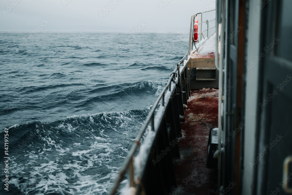 Fishing ship is swimming at sea at winter