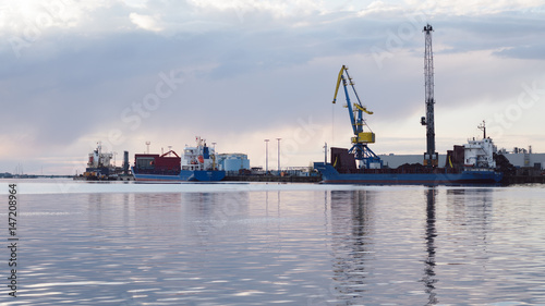 cranes at harbor against sky