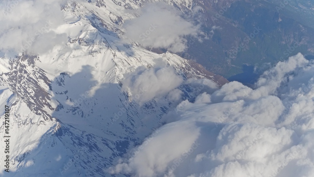 The Alps snowy mountain peaks and white clouds, aeial view The Alps snowy mountain peaks and white clouds, aeial view