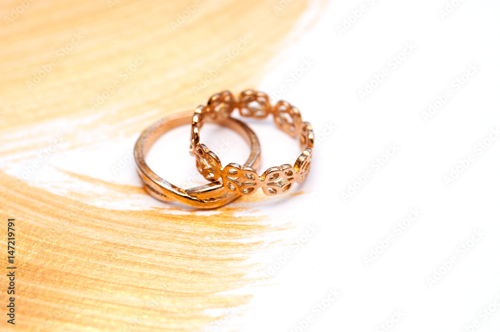 Two gold wedding rings on an abstract gilded acrylic background Two gold wedding rings on an abstract gilded acrylic background