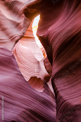 Pink peach wave shapes photographed at slots canyons in Arizona with blue sky