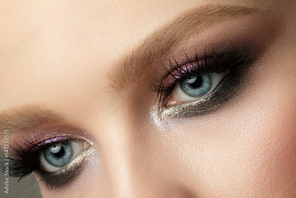 Close up of blue woman eye with smokey eyes makeup Close up of blue woman eye with smokey eyes makeup