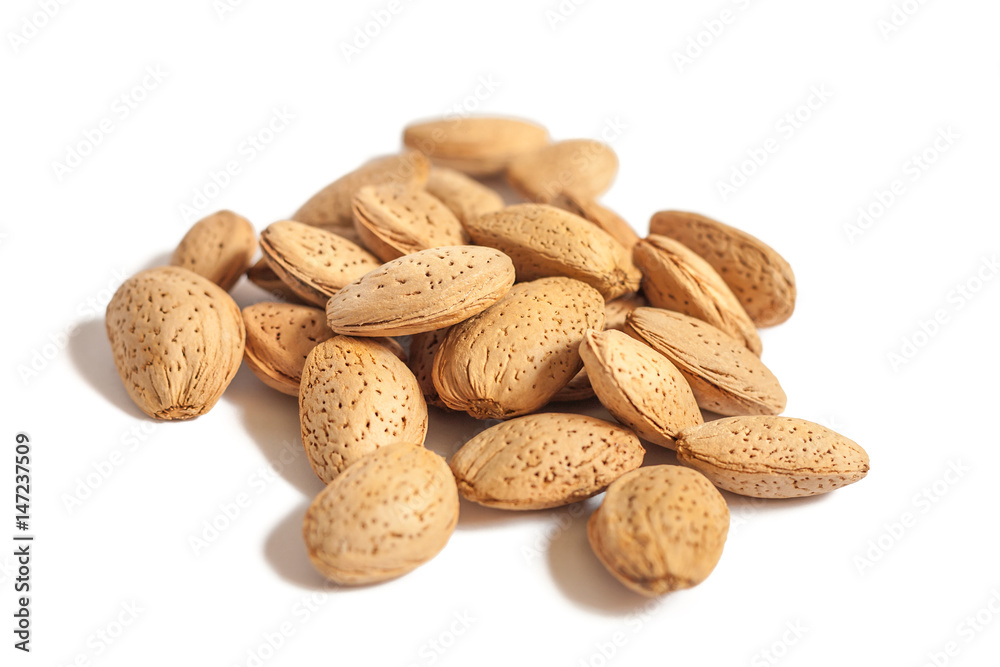 A lot of almond nuts in the shell isolated on white background, selective focus A lot of almond nuts in the shell isolated on white background, selective focus