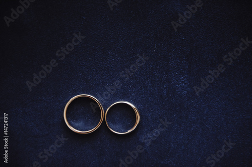 Wedding rings on a blue suede background. Wedding details.