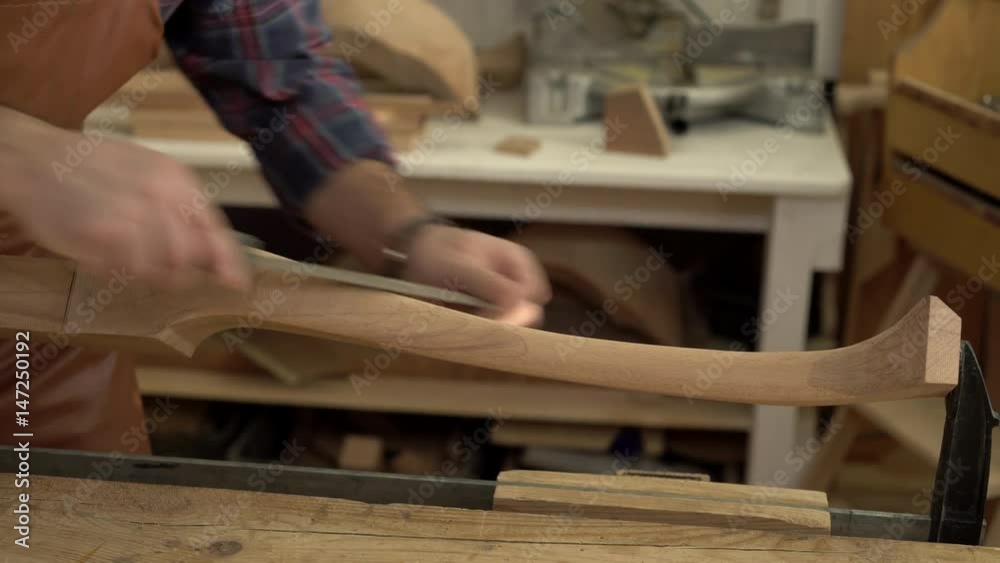 Carpenter Polishes Cabrioli Leg in his Workshop/Cabinet maker polishes the cabriolet leg with a file. He works in a small family joiner’s shop Carpenter Polishes Cabrioli Leg in his Workshop/Cabinet maker polishes the cabriolet leg with a file. He works in a small family joiner’s shop
