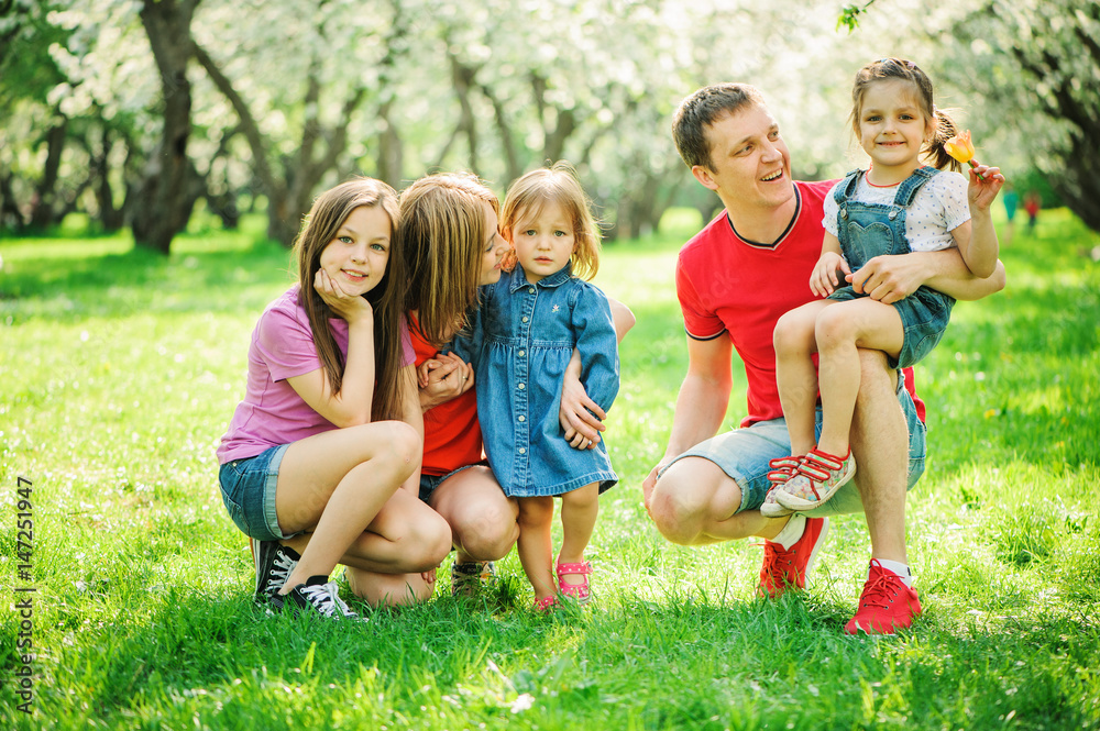 Fototapeta premium big family with three little daughters spending time together in summer park, mother, father and sisters having fun outdoor