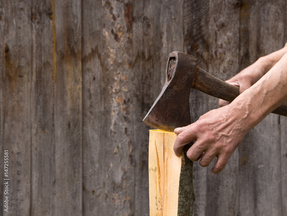 The old axe in the hands of an elderly person colitis firewood The old axe in the hands of an elderly person colitis firewood