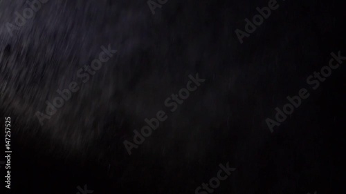 Some dust of liquid particles flowing on dark background photo