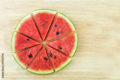 Sliced watermelon on wood background.
