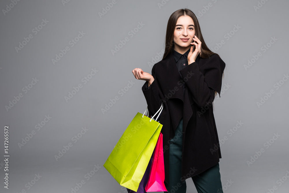 Trendy modern shopping woman carrying bag typing on the smartphone. Trendy modern shopping woman carrying bag typing on the smartphone.