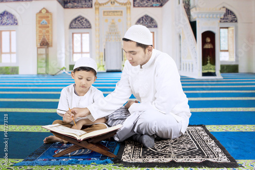 Canvas Print Father teaching son to reads Koran