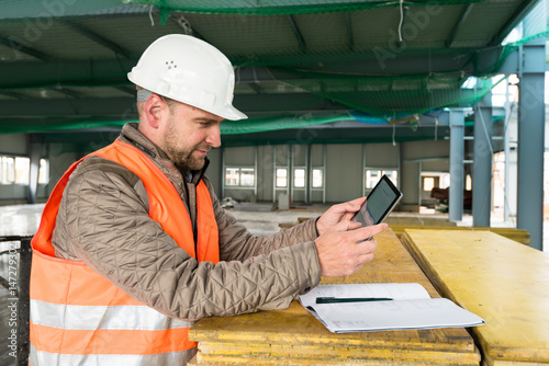 Construction supervisor with digital tablet on site