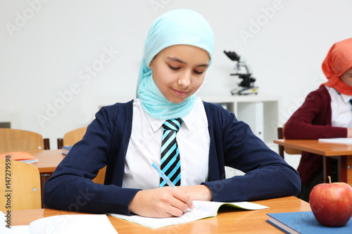 Cute girl sitting at desk i...