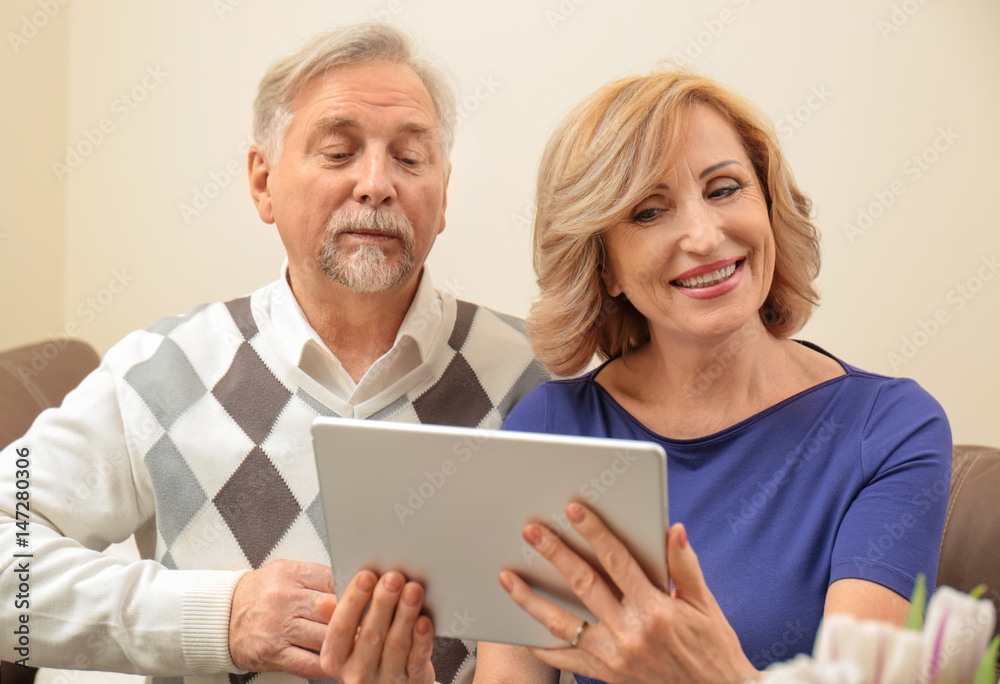 Cute elderly couple with tablet computer at home Cute elderly couple with tablet computer at home