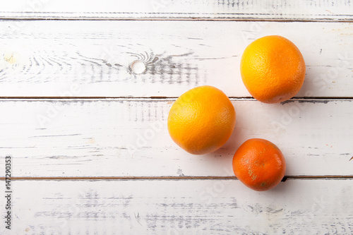 Fresh organic orange and mandarin on white wooden table, top view.
