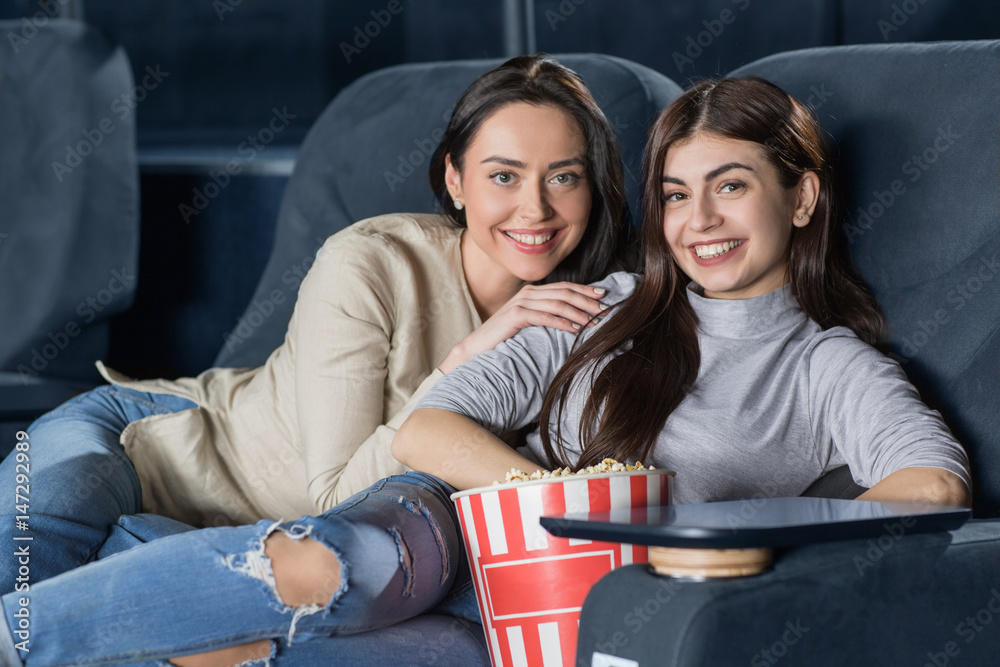 Εκτύπωση καμβά Two female friends watching a movie at the cinema together