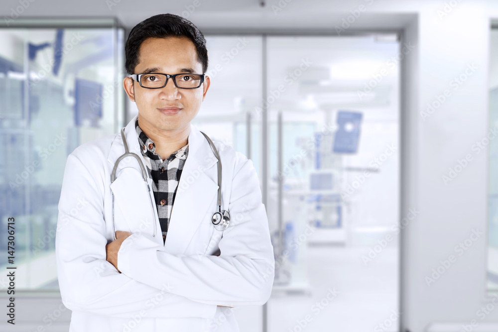 Young doctor standing in medical room Young doctor standing in medical room