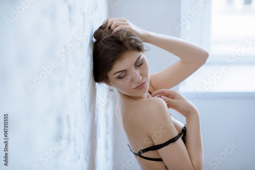 Female portrait of cute lady in black bra indoors. Close up beautiful sexy model girl in elegant pose. Closeup beauty brunette woman with hairstyle
