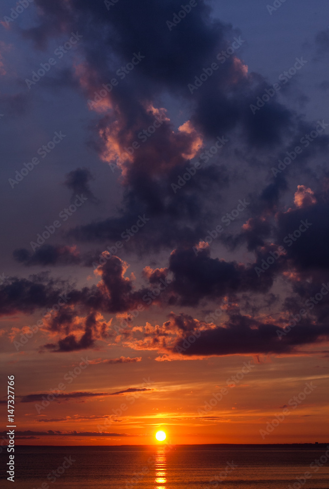 Fototapeta premium Colorful sunset of a cloudy day at sea