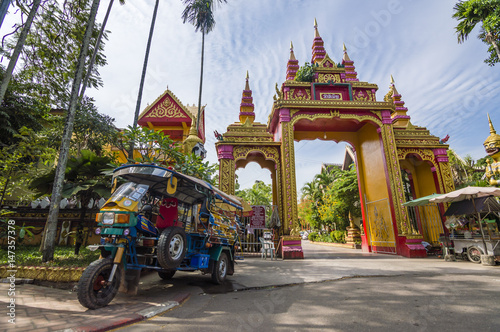 Tuk tuk motorbike taxi in Wat Si Muang Buddhist temple in Vientiane, Laos photo